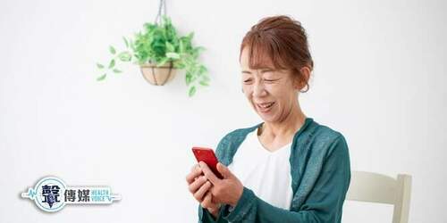 熟齡女士正在快樂地使用智慧型手機