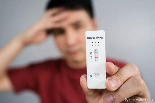 young stressed man holding coronavirus covid 19 positive test result with antigen rapid test kit atk 1